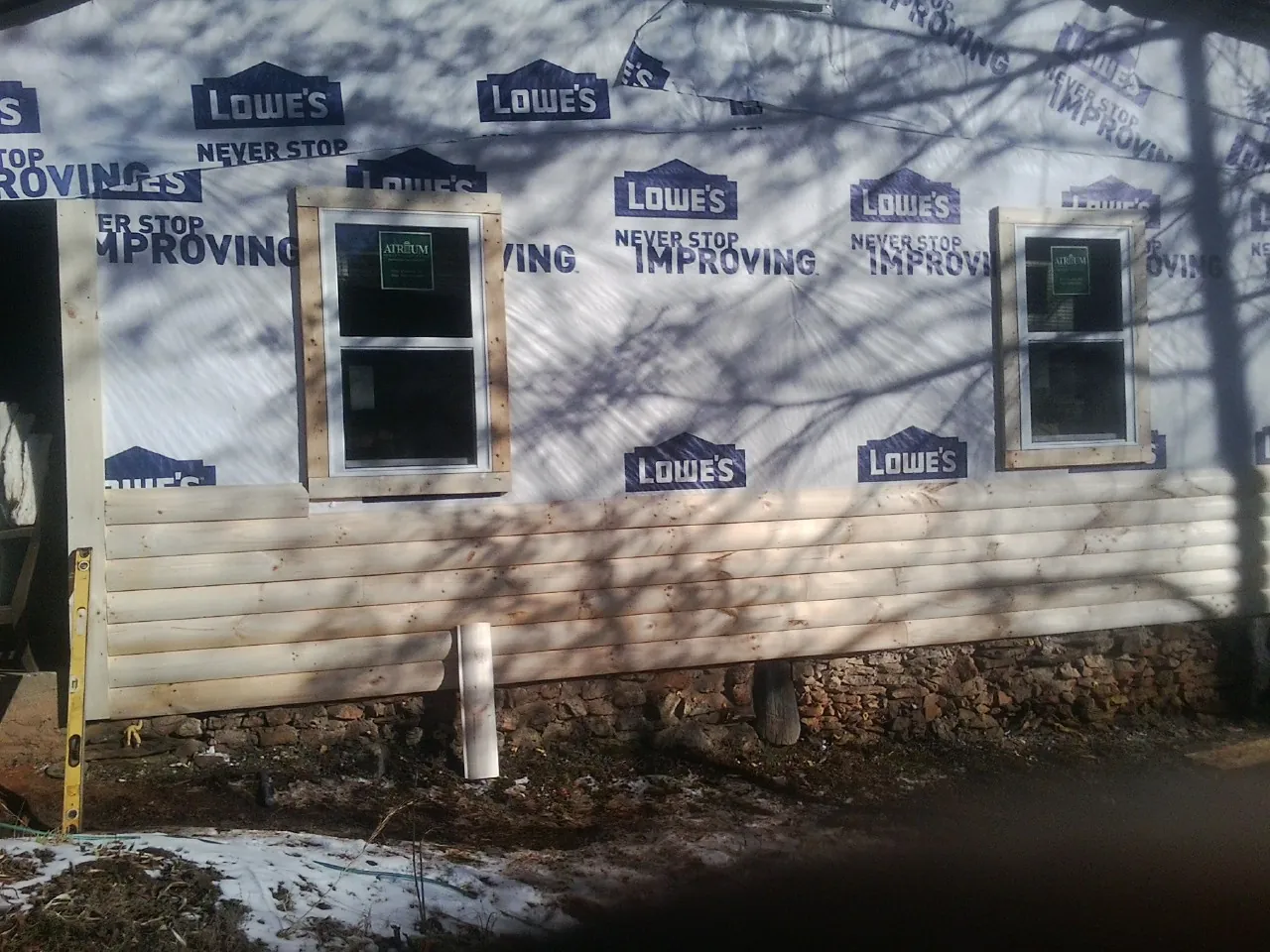 House wrap and new log siding going up on an exterior wall in Ravenna