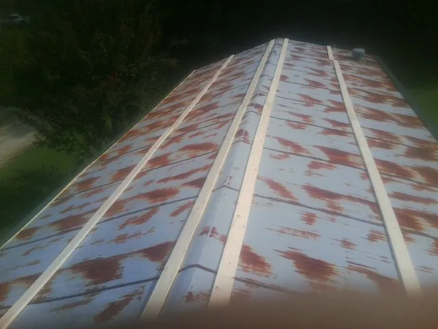 Rusted metal roof panels with new wood purlins before replacement — Storm Damage Roof Repair in Ravenna by Roofing Brothers